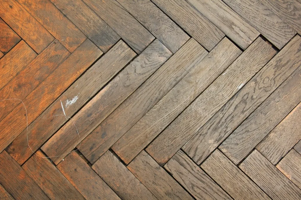 Antes: parquet en espiga gastado, con manchas y lamas dañadas